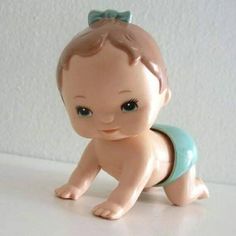 a little baby doll sitting on top of a white table with a blue diaper