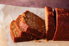 sliced loaf of banana bread sitting on top of a piece of wax paper