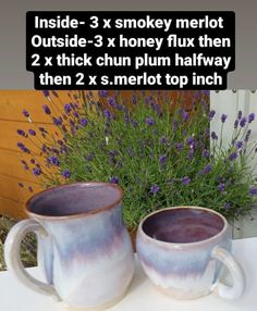 two mugs sitting next to each other on a table with lavender flowers in the background