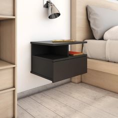 a nightstand with a book on it next to a bed in a room that has white walls and wood flooring