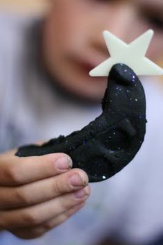 a small child holding a black toy with a white star on it's tip