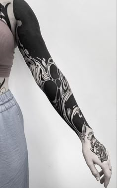 a woman's arm with black and white tattoos on her left arm, in front of a white background