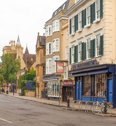 an empty street with buildings and bicycles parked on the side walk in front of it