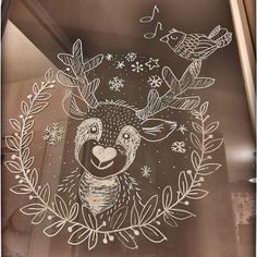 a glass window with a deer drawn on it's face and birds flying around