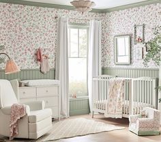 a baby's room with floral wallpaper and white furniture, including a crib