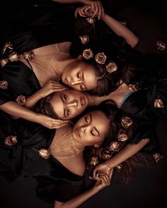 three women in black dresses laying on the ground