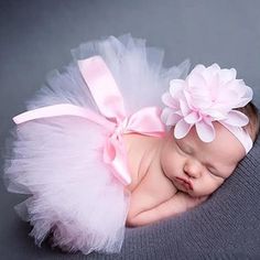 a newborn baby girl wearing a pink and white tutu