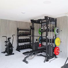 a home gym with several different types of exercise equipment in the room and on the wall