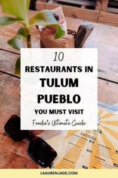 a wooden table with sunglasses and menus on it that says 10 restaurants in tulum pueblo you must visit