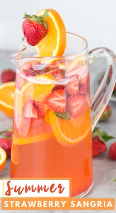 a pitcher filled with oranges and strawberries