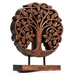 an intricately carved wooden tree with leaves on it's head, is displayed against a white background