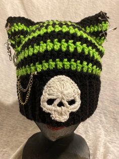 a crocheted hat with a skull on the front and chain at the bottom