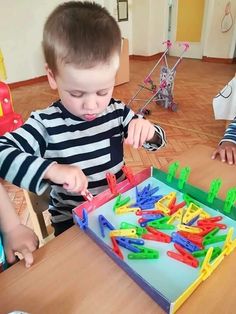 two young boys playing with toys at a table