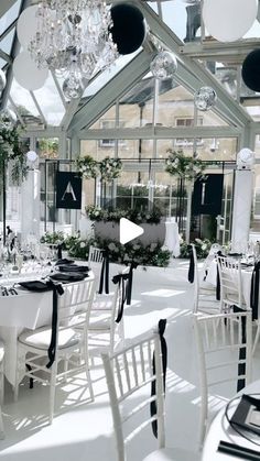 a room filled with lots of white tables and chairs