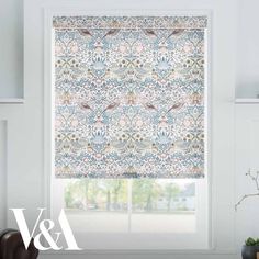 a window with a blue and green floral pattern on the blind in front of it