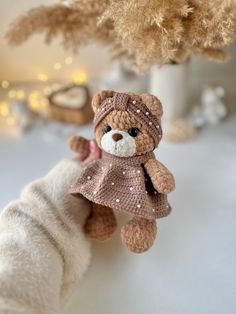 a small teddy bear wearing a pink dress