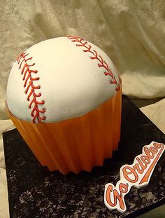 a cupcake with a baseball on top is sitting on a table