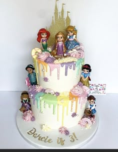 a birthday cake with princess figures on top