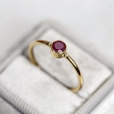 This dark red Ruby Ring in gold is perfectly minimal, modern and feminine. Can be worn alone for ultimate simplicity, or mix, match & stack for a fun, unique look. Featuring a single solitaire ruby bezel set into a simple, smooth 14k Gold Filled band. The Ruby is 4mm, in a round cut, and a rich deep dark raspberry red. This ring is also available as part of a set of either two or fours stacking rings - please see links further below under 'MATCHING ITEMS'. A 'fine jewellery' ring - simple &a Modern Gold Ruby Ring As Gift, Modern Gold Ruby Ring For Gift, Minimalist 14k Gold Red Ruby Ring, Modern Ruby Birthstone Ring, Gold Minimalist Open Ruby Ring, Minimalist Gold Open Ruby Ring, Minimalist Red Ruby Ring, Minimalist Gold Ruby Ring For Formal Occasions, Modern 14k Gold Ruby Ring