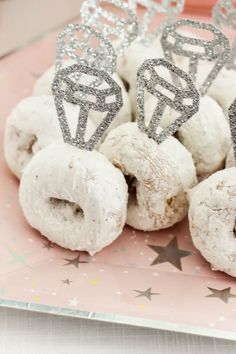 there are many donuts on the plate with tiaras around them for desserts