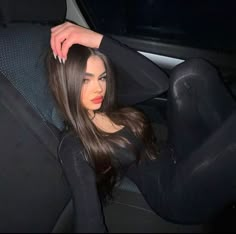 a woman sitting in the back seat of a car