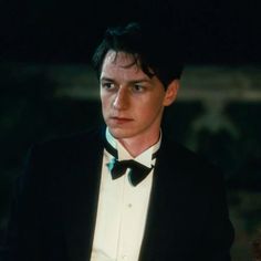 a young man in a tuxedo looks at the camera