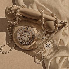 a drawing of an old fashioned telephone with beads on the cord and a bottle of perfume