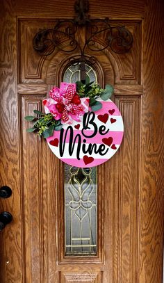 a wooden door with a sign that says be mine and flowers on the front porch