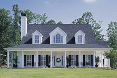 a white house with black shutters and wreath on the front door