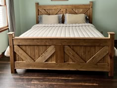 a bed with wooden headboard and foot board on hardwood flooring in a bedroom