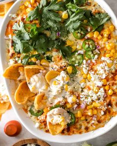 a white bowl filled with tortilla shells and garnished with cilantro