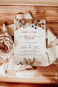 a wedding card with a rose on it next to some napkins and paper flowers