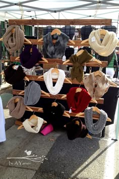 hats and scarves are on display at an outdoor market