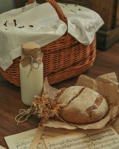 bread sitting on top of sheet music next to a bottle of milk and some papers