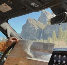 a man sitting in the driver's seat of a vehicle looking at a map