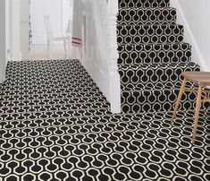 a black and white carpeted hallway with stairs