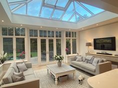 a living room filled with furniture and a flat screen tv mounted on the wall above it