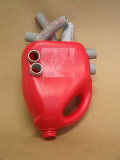 a red gas can sitting on top of a brown table next to some screws