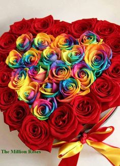 a heart shaped box filled with multicolored roses