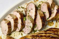 sliced pork on a plate with sauce and parsley