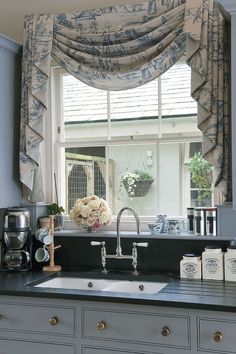 a kitchen sink under a window next to a counter