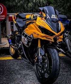 a yellow and black motorcycle parked in front of a building