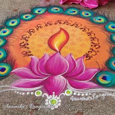 a colorful painting on the ground with peacocks around it and a candle in the center