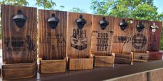 four wooden boxes with different designs on them sitting on a table outside in front of some trees