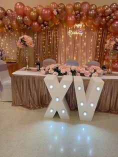 the table is decorated with pink flowers and balloons