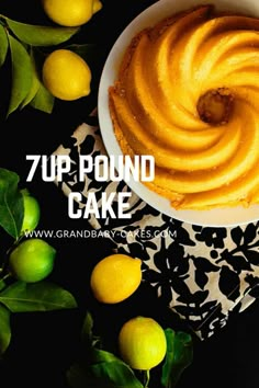 a white bowl filled with yellow cake next to lemons and green leafy leaves