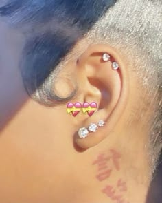 a close up of a person's ear with two hearts on it and three diamonds in the middle