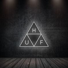 a dark room with three spotlights on the wall and an illuminated h u f logo