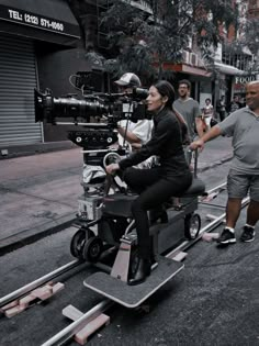 a woman sitting on top of a motorized scooter in the middle of a street