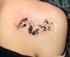 the back of a woman's shoulder with butterflies on it